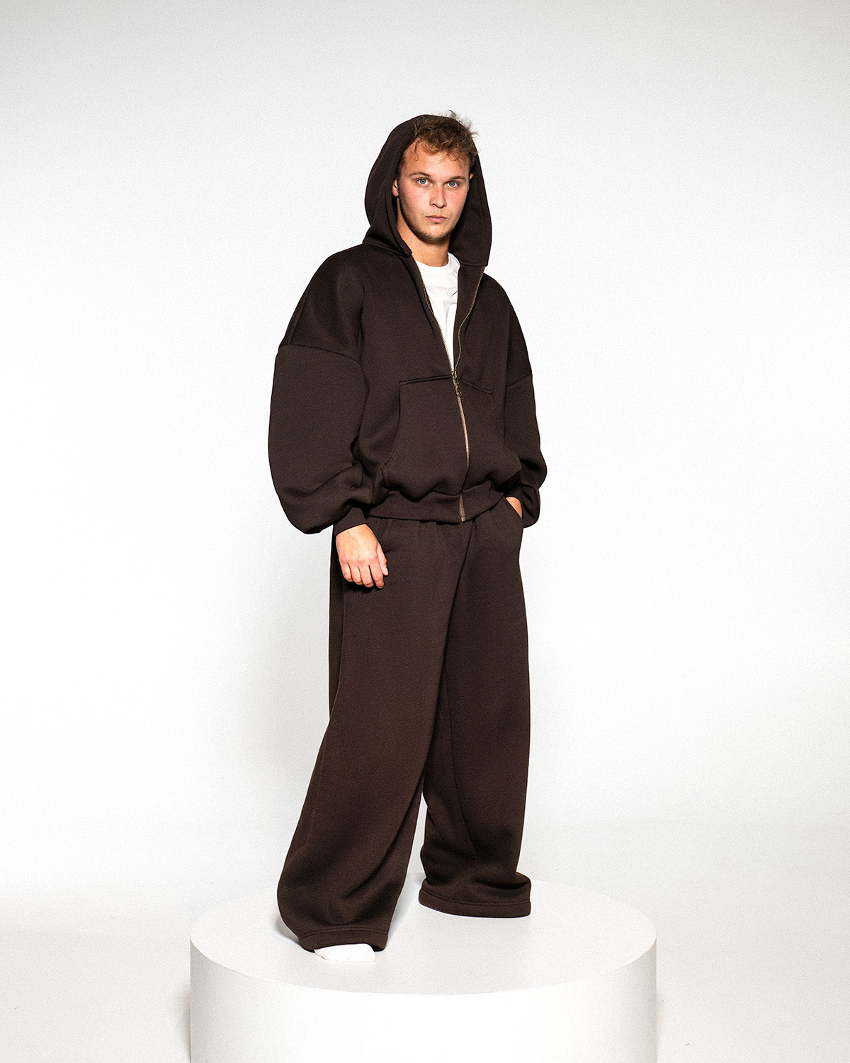 Model wearing a dark brown tracksuit with a zip, full length