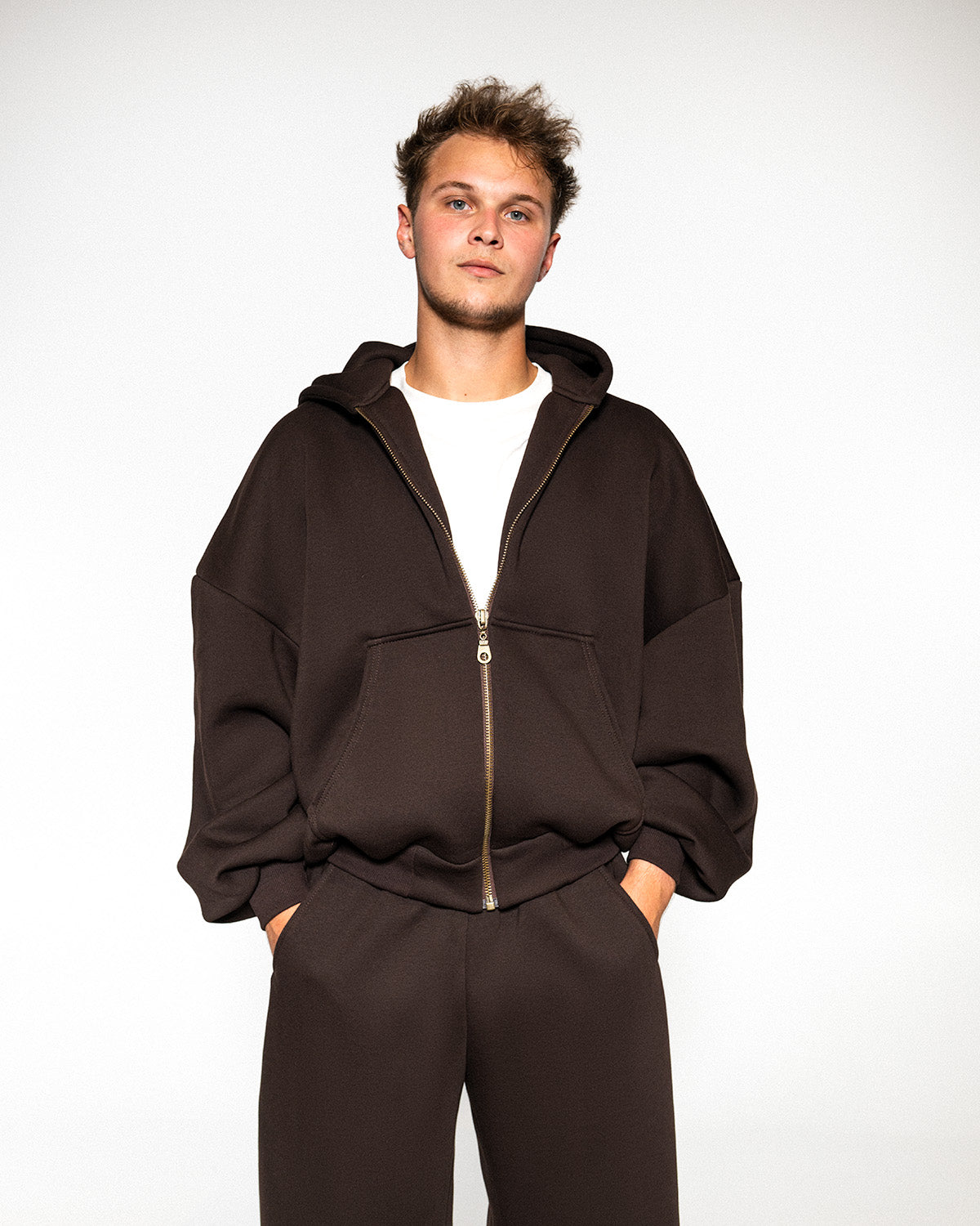 Dark brown zip hoodie close up, showing the brass zip